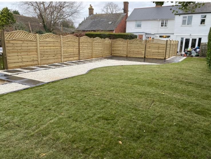 Freshly laid lawn with new fencing and a hedge line