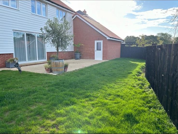 Newly turfed lawn and new fencing behind a house