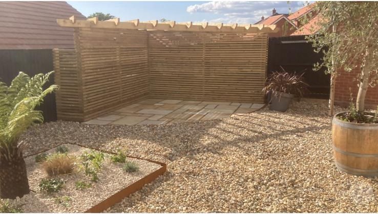 Horizontal slatted fence with a gravel bed